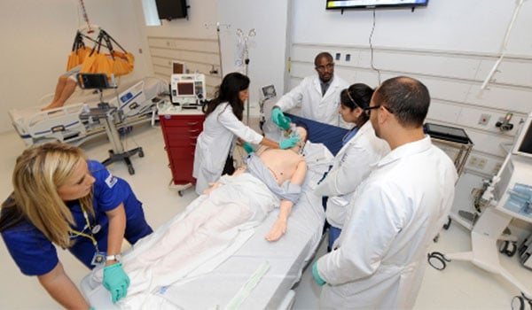 Students participating in simulation on dummy patient